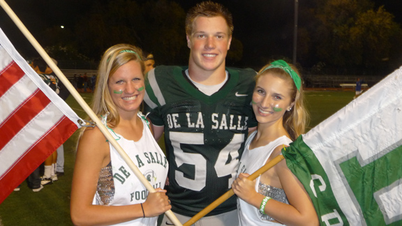 Senior line standout Sumner Houston from De La Salle of Concord gets greeted by flag girls after one of the team's 15 wins during the 2012 season. Houston and his other linemen teammates are going to be a major force for the Spartans this year. 