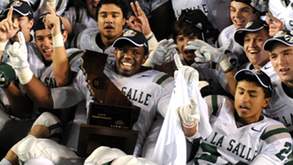 De La Salle senior Michael Hutchings has the CIF Open Division state title trophy in his lap as he and his teammates celebrate after they beat Centennial of Corona 48-28 on Saturday night. Photo by Scott Kurtz.