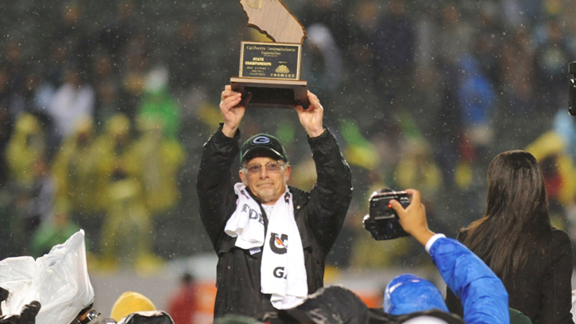 Granite Bay head coach Ernie Cooper raises the CIF Division I state bowl game trophy after his team rallied in the final two minutes to beat Long Beach Poly on Dec. 14 at The Home Depot Center. Photo by Scott Kurtz.