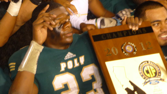 Long Beach Poly running back Gerard Wicks holds CIFSS Pac-Five title plaque during photo shoot.