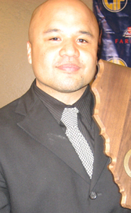 Alemany head coach Bryan Camacho poses with last year's CIF Division III girls state title trophy.
