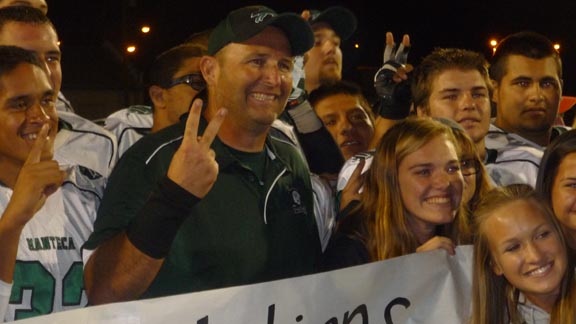 Manteca head coach Eric Reis poses with family, friends and players after his 100th victory at the school on Friday. For recap of win over Oakdale, CLICK HERE. Photo: Mark Tennis.