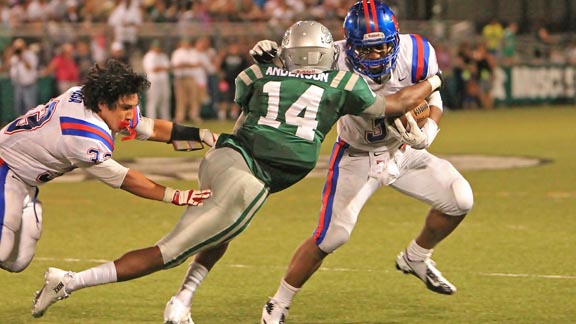 Clayton Valley junior running back Miles Harrison looks for running room in earlier game vs. De La Salle as teammate Rueben Vega loses his helmet. Photo by Jason Rogers.