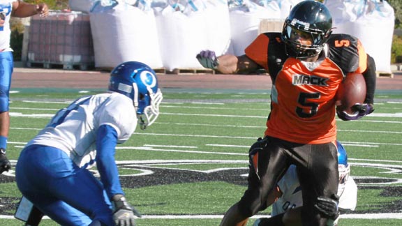 Lavance Warren from McClymonds of Oakland is about to deliver a stiff arm to Oakland High defender in last Friday's Silver Bowl game won by McClymonds. Photo: Willie Eashman.