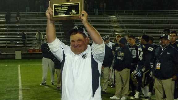 Central Catholic coach Roger Canepa salutes team's supporters by raising plaque after CIF Division IV state bowl game win over McClymonds. Photo: Mark Tennis.