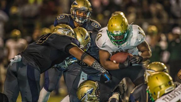 Long Beach Poly running back James Brooks is stopped by several tacklers from No. 1 St. John Bosco in CIFSS Pac-5 Division semifinal. Photo: Terry Jack/OCSidelines.com.
