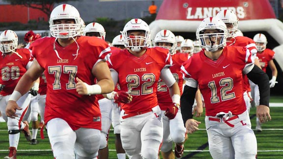 Alex Dalpe, Jordan Williams and T.J. Augustin charge out onto the field for new No. 21 Orange Lutheran before the team's game last Friday vs. Vista Murrieta. Photo: WeAreOLu.org.