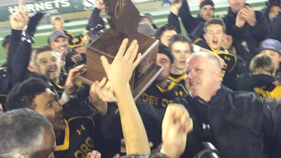 Del Oro head coach Casey Taylor hands CIF Division II-AA state title plaque over to his players after victory over Camarillo on Friday in Sacramento. Photo: Mark Tennis.