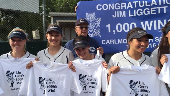 Carlmont of Belmont softball coach Jim Liggett stands with players sporting t-shirts and with a sign commemorating historic 1,000th victory. Photo: Harold Abend.