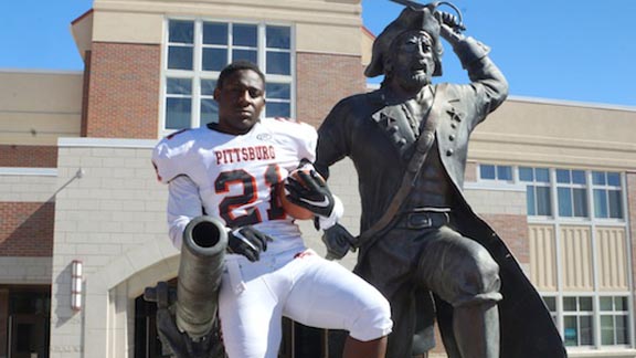 Pittsburg High running back Montaz Thompson, whose team stayed No. 13 this week in the state, poses with statue outside school. Photo: Phillip Walton/SportStars.