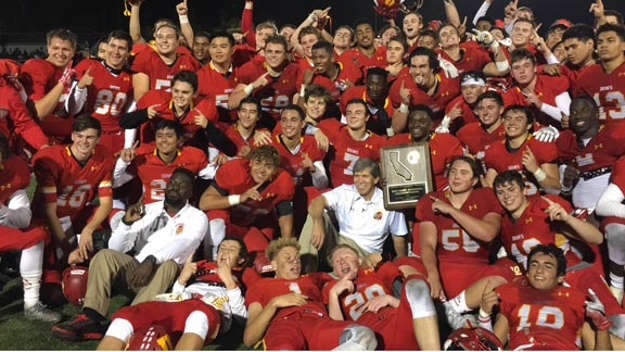 Players at Cathedral Catholic (San Diego) hold CIF SoCal D1-AA title plaque right near the ear of head coach Sean Doyle after win last Friday vs. Narbonne. Photo: Thomas Gutierrez.