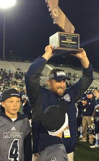San Diego Madison head coach Rick Jackson raises a CIF state title trophy for the second time in his career as his two sons stand nearby. Photo: Mark Tennis.