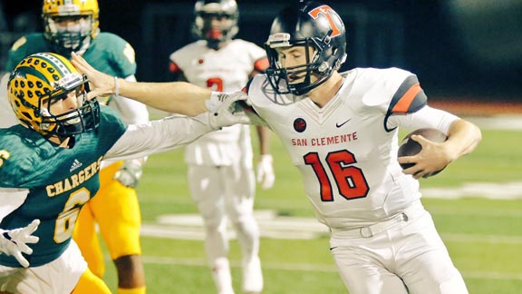 San Clemente QB Jack Sears uses stiff arm against Huntington Beach Edison's Nick Warren during CIF SoCal Division 1-A final. Photo: Patrick Takkinen/SoCalSidelines.com.